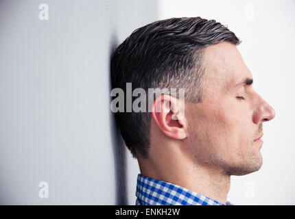 Side view portrait of a relaxed man leaning on the wall Stock Photo