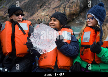 Passengers of Safari Endeavour cruise playing with a big ice at Fords Terror, Endicott Arm, Tongass National Forest, Alaska, USA Stock Photo