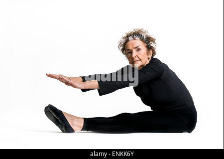 studio portrait of 83 old looking good white senior gymnast woman on white background exercising Stock Photo