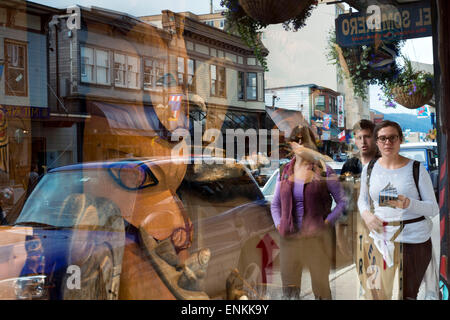 People reflected in the showcase of Totem Pole Shop, Juneau Alaska. Indigenous crafts shop, Juneau, Alaska. Local Indian Art and Stock Photo