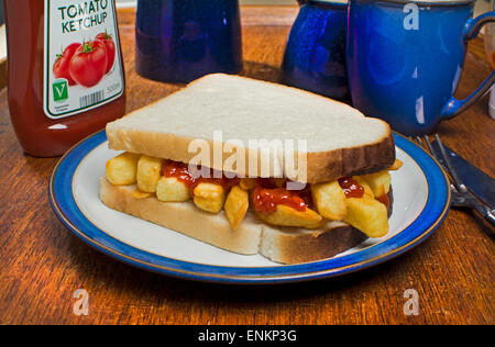 A potato chips sandwich, commonly known as a chip butty in the UK, with tomato ketchup sauce Stock Photo
