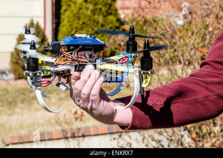 A 50 year old Caucasian man holds his DYI built quad copter. Stock Photo