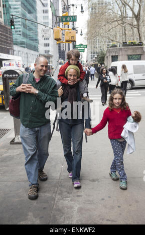 Family walking down 6th Avenue in midtown Manhattan, NYC. Stock Photo