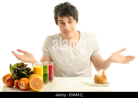 Man choosing between fruits, smoothie,salad and organic healthy food against sweets, sugar, lots of candies Stock Photo