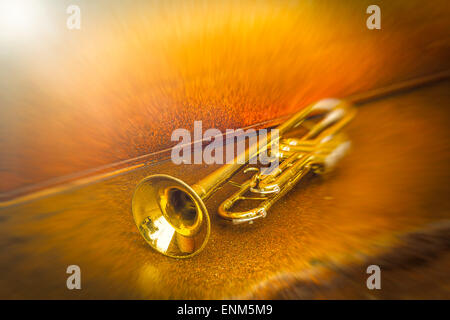 Old worn trumpet stands alone against a grungy wall outside a jazz club Stock Photo