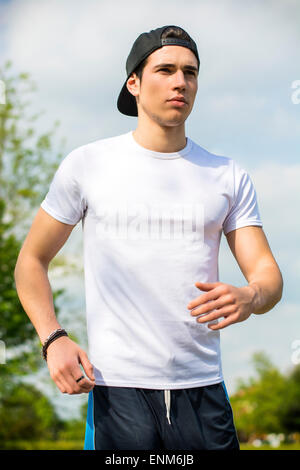 Young man running and jogging on road in country Stock Photo