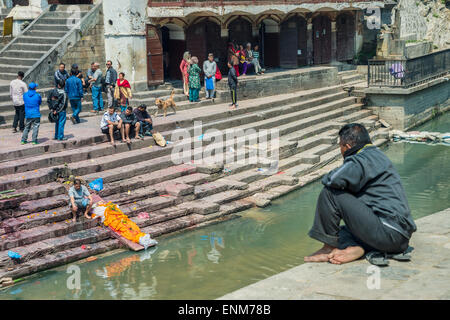 Pashupatinath Temple in Kathmandu. A dead body is washed by a relative Stock Photo