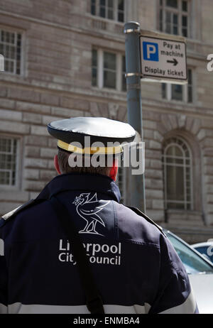 City Council Parking warden checking time & issuing a parking fine, Liverpool, Merseyside, UK Stock Photo