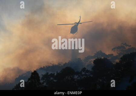 (150508) -- LOMA MIRANDA, May 8, 2015 (Xinhua) -- A helicopter tries to extinguish a forest fire in Loma Miranda of La Vega Province, the Dominican Republic, May 7, 2015. (Xinhua/Onelio Dominguez) Stock Photo