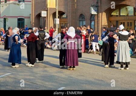 Dancers in traditional Dutch attire face each other as they begin performing Klompen dancing at Tulip Time in Holland, Michigan Stock Photo