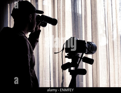 man with binoculars and camera control someone Stock Photo