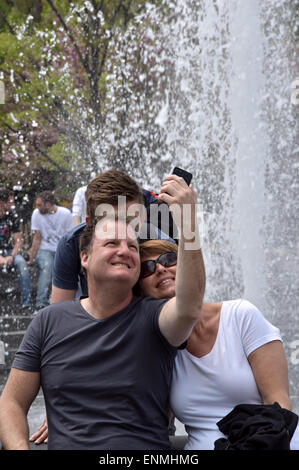 An tourist family taking a selfie near the fountain in Washington Square Park in Greenwich Village, New York City Stock Photo