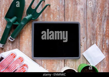 close up of tablet pc and garden tools on table Stock Photo