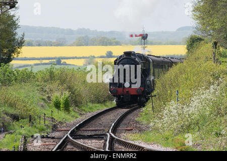 Steam train rounds approaches Ropley station on the Watercress Line, Hampshire England on a summers day. Stock Photo