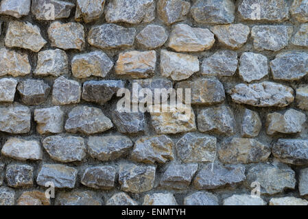 A wall made from many small square stones. Stock Photo