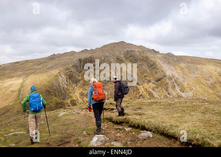 Three hikers hiking on Minffordd path to Penygadair summit of Cadair Idris massif mountain range in Snowdonia National Park (Eryri) Wales UK Britain