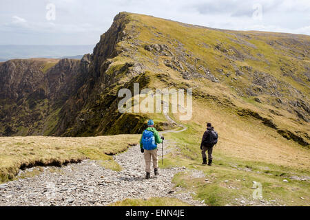 Hikers on Minffordd path from Penygadair to Craig Cau peak in Cadair Idris mountain range in Snowdonia Wales UK