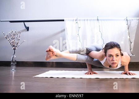 Strong Female holds yoga arm balance Stock Photo