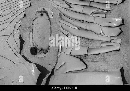 Old flaking paint peeling off wood with deep shadows in black and white Stock Photo