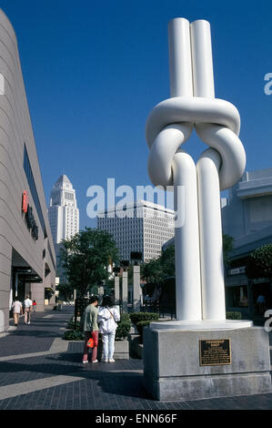 Japanese-American sculptor Shinkichi Tajiri created the 'Friendship Knot' that is a well-known monument in the Little Tokyo Historic District in Los Angeles, California, USA. The 18-foot-tall (5.49 meters) artwork with its white fiberglass surface was a gift to the city for its bicentennial in 1981.  It was made in 1972 and first displayed in the Netherlands where the artist made his home for 53 years until his death in 2009 at the age of 85. The sculpture is located next to a multi-level outdoor shopping center called Weller Court, and within sight of the tall landmark Los Angeles City Hall. Stock Photo