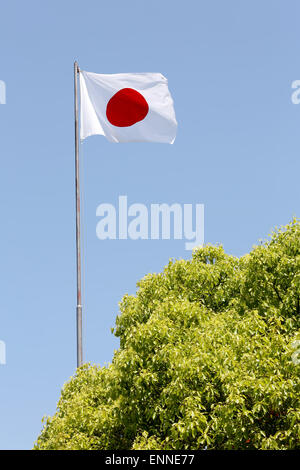 Japanese flag in wind against clear blue sky Stock Photo