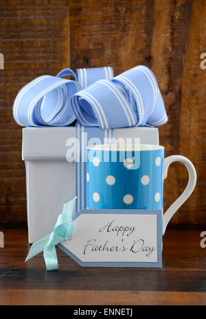 Happy Fathers Gift with blue and white gift and polka dot coffee mug on wood background. Stock Photo