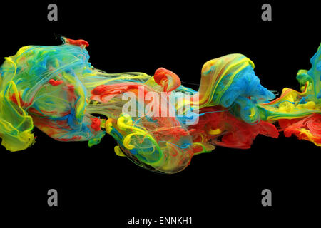 Colorful ink and paint swirling through water Stock Photo