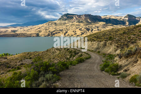 The arid landscape of Buffalo Bill State Park with the Shoshone River flanked by rolling landscape and mountains  at dawn. Stock Photo
