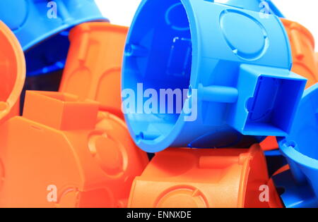 Heap of blue and orange plastic electrical boxes, components for electrical installations, accessories for engineering jobs Stock Photo