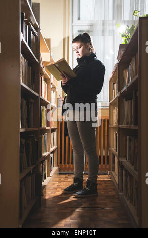 Student girl in a library. Looking at book Stock Photo