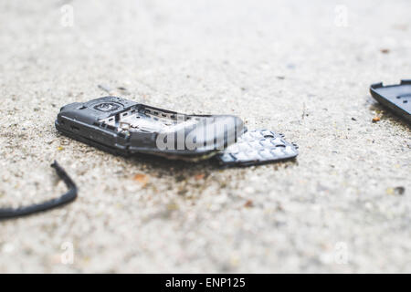 Old broken mobile phone on the road Stock Photo