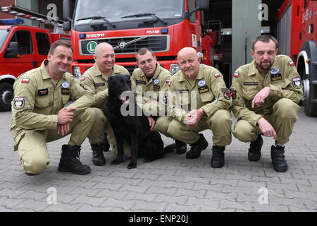 Gdansk, Poland 9th, May 2015 Polish firefighters from Gdansk back to Poland from Nepal. Polish rescuers took part in the rescue action after the earthquake in Nepal. There were 6 firefighters and rescue dog from Gdansk. Firefighter with dog named Kali stand in front of the fire rescue cars Stock Photo