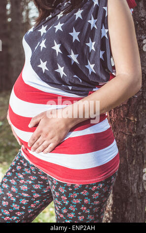 Pregnant woman in the forest. American national flag shirt Stock Photo