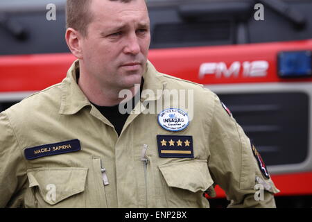 Gdansk, Poland 9th, May 2015 Polish firefighters from Gdansk back to Poland from Nepal. Polish rescuers took part in the rescue action after the earthquake in Nepal. There were 6 firefighters and rescue dog from Gdansk. Firefighter Maciej Sapieha who back from Nepal stands in front of the fire rescue cars Stock Photo