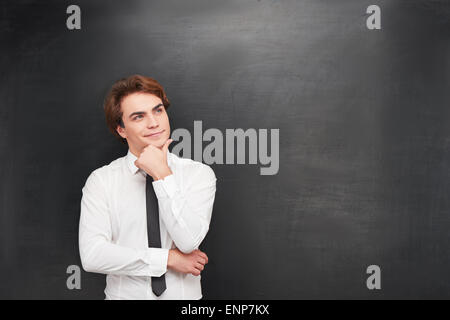Smiling young man on chalkboard background Stock Photo