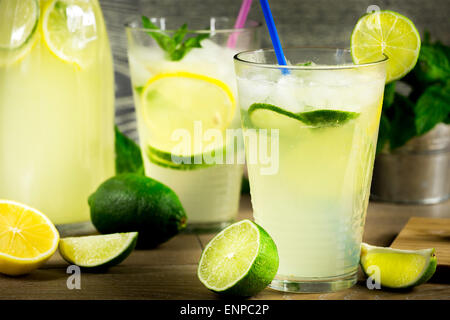 Refreshing lemonade drink and ripe fruits against wooden background Stock Photo