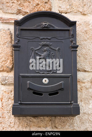 Antique black metal mail box on the old wall Stock Photo