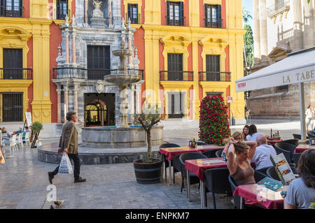 Malaga, Spain. Malaga, Spain. People sitting at a terrace by the Bishop's Palace (Palacio Episcopal) at Bishop Square (Plaza del Stock Photo