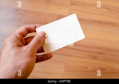 Man hand hold note with wood table office background Stock Photo