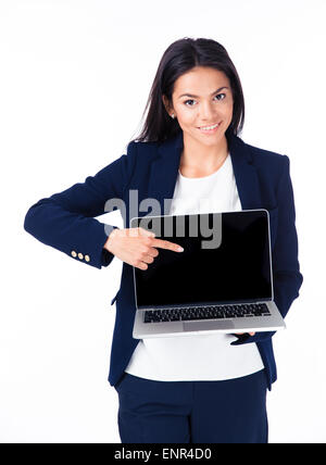 Smiling businesswoman pointing finger on the blank laptop screen over white background and looking at camera Stock Photo