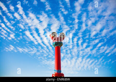 iron, red fire hydrant against a blue sky Stock Photo