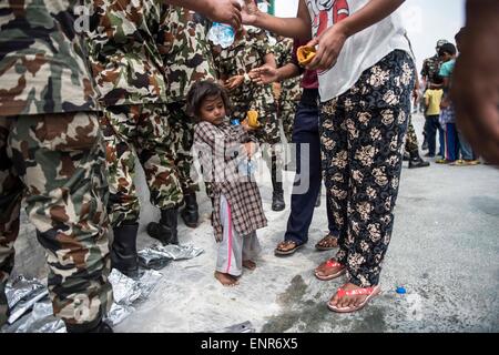 Kathmandu, Nepal. 10th May, 2015. A child holds food and water distributed by Nepalese military in Kathmandu, capital of Nepal, on May 10, 2015. Credit:  Liu Siu Wai/Xinhua/Alamy Live News Stock Photo