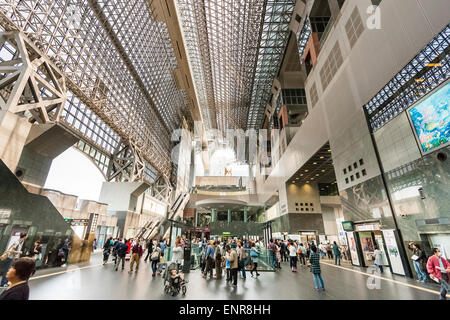 Japan, Kyoto JR station, designed by Hiroshi Hara. Interior view along station building with the concourse busy with people and commuters. Daytime. Stock Photo