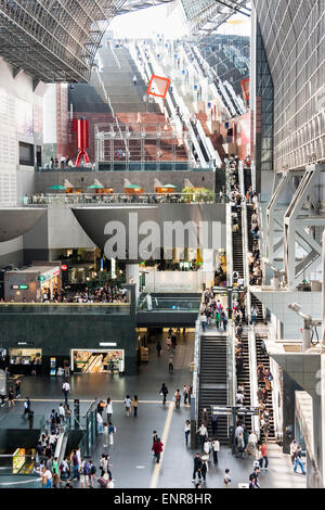 Japan, Kyoto JR station, designed by Hiroshi Hara. Interior view along station building with the concourse busy with people and commuters. Daytime. Stock Photo