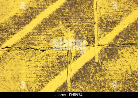Worn texture with yellow stripes on asphalt Stock Photo