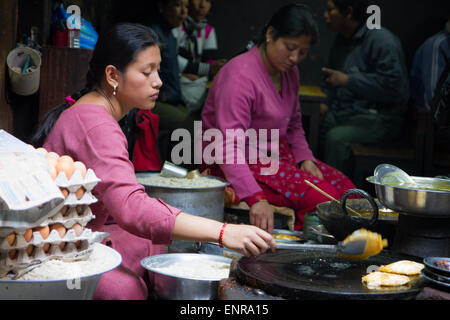 Women cooking dosa in Newari restaurant in historic Patan, Kathmandu, Nepal Stock Photo