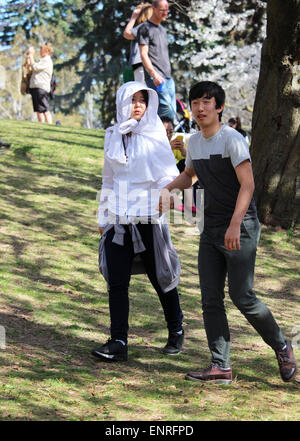 A young Asian couple taking a walk in the park. Stock Photo