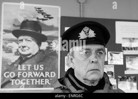 Old sailor wearing Royal Navy officers cap in front of Winston Churchill world war 2 campaign poster Stock Photo