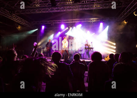 Rock band performing live on stage at the Bourges Festival with youth dancing in the audience Stock Photo