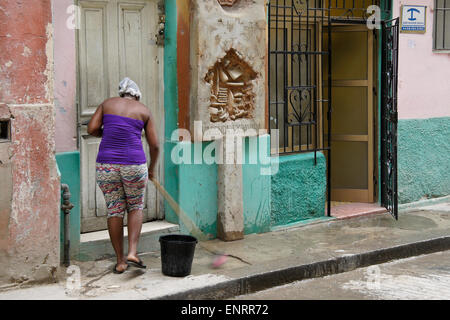 Woman cleaning sidewalk in front of home, Habana Vieja (Old Havana), Cuba Stock Photo